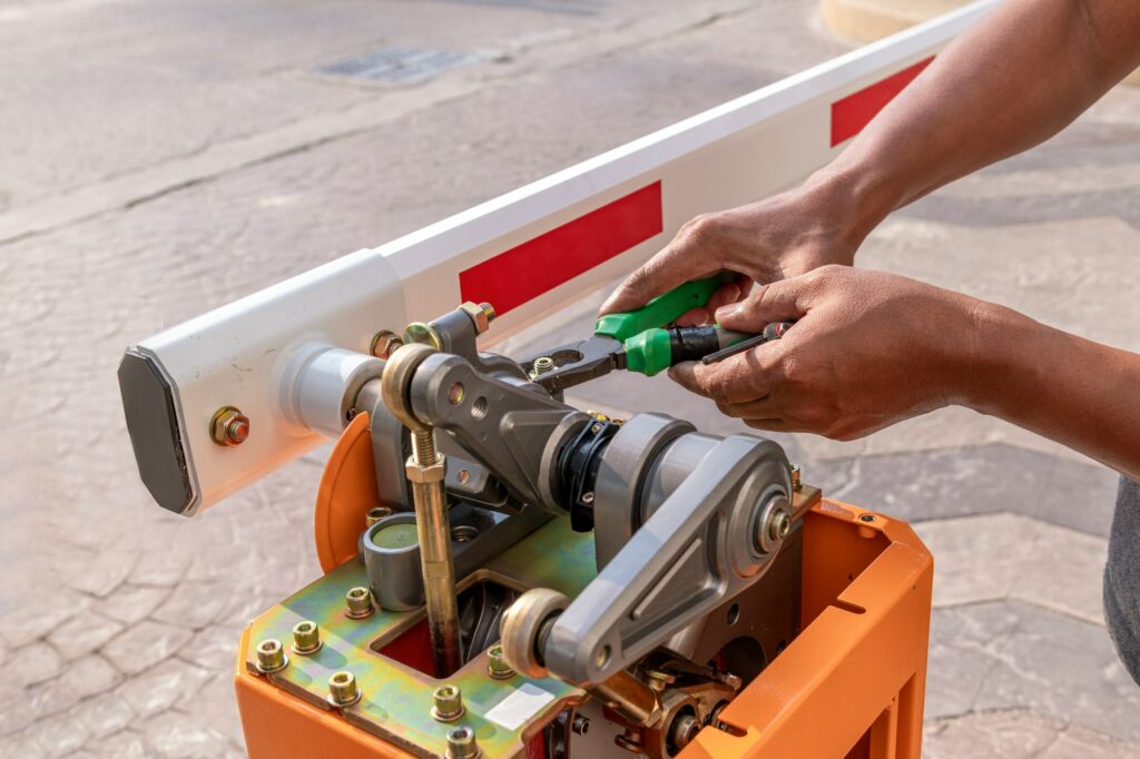 Close up technician assemble barrier gate automatic system for control entrance way security area